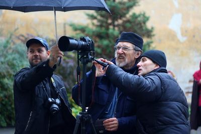 The crew at the camera under an umbrella