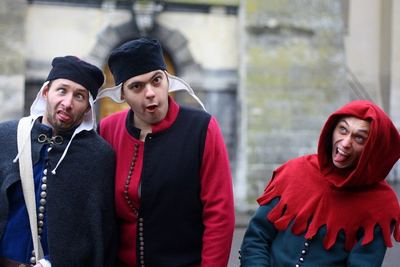 Three actors in medieval costume pulling faces