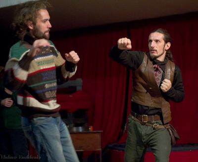 Rehearsing the fight scene in front of a red curtain