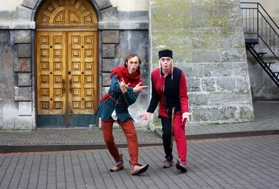Two actors in front of an old door